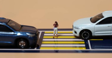 Miniature people and miniature cars. A concept about warning of the risk of using a Smartphone when crossing a crosswalk. clipart