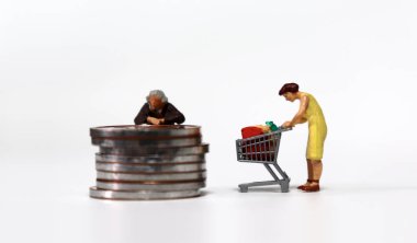 Elinde bozuk para ve alışveriş arabası olan minyatür bir kadın..