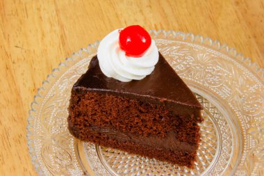 Üstünde kırmızı jöle olan çikolatalı pasta.