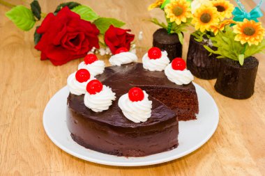 Üstünde kırmızı jöle olan çikolatalı pasta.