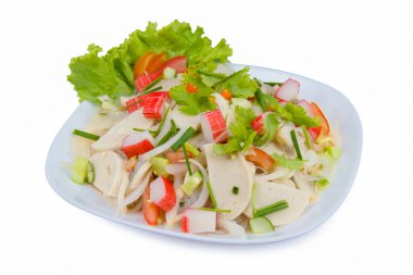 Beyaz tabakta domuz sosisi baharatlı salata.