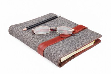 Kalem, gözlük beyaz arkaplanda defter üzerinde