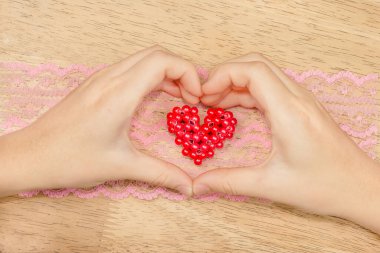 Kırmızıya dönüşmüş kalbi gösteren eller.