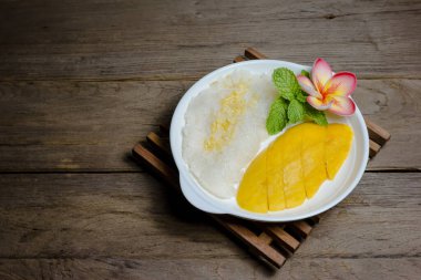 Ahşap zemin üzerinde yapışkan pirinç ile olgun Mango