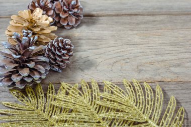 Tahtadaki çam kozalakları ve altın yaprak, Noel arkaplanı.