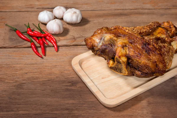 Ahşap arka planda kızartılmış domuz budu.