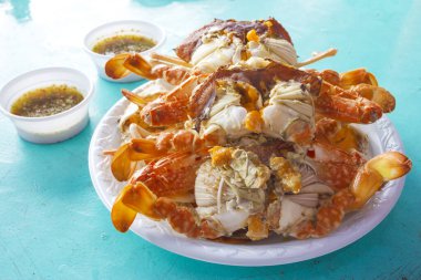 Mavi masada baharatlı soslu haşlanmış yengeç.