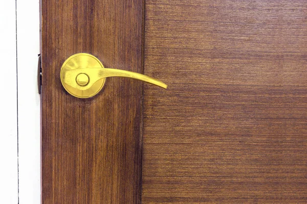 Golden door knob on wooden door