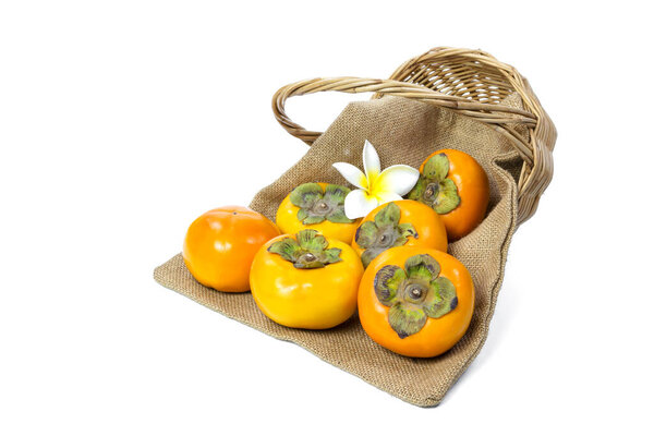 Persimmon with sack and wicker basket isolated on white background