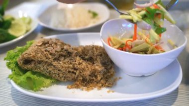 Mango salatalı çıtır yayın balığı yiyen kişi, Tayland yemeği, yavaş çekim hareketi