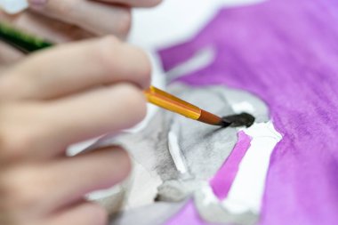 Ressam ressamların suluboya resimleriyle fırçayı tutan yakın plan elleri