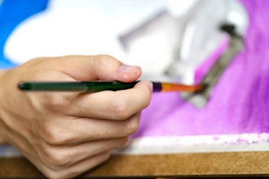 Ressam ressamların suluboya resimleriyle fırçayı tutan yakın plan elleri