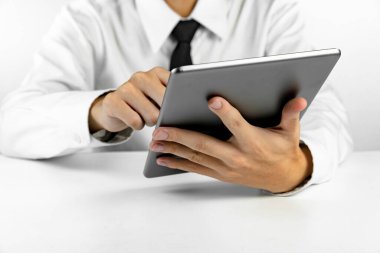 Beyaz arkaplanda tablet kullanan işadamı