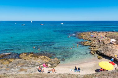 Güney İtalya, Puglia 'daki harika Akdeniz sahili sahillerinde kristal berrak sularda yüzüyorlar.