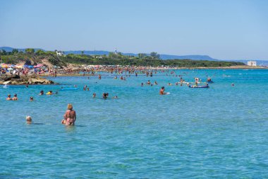 Güney İtalya, Puglia 'daki harika Akdeniz sahili sahillerinde kristal berrak sularda yüzüyorlar.