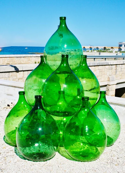 Pyramid set of vintage green glass large bottles demijohns for wine, vertical
