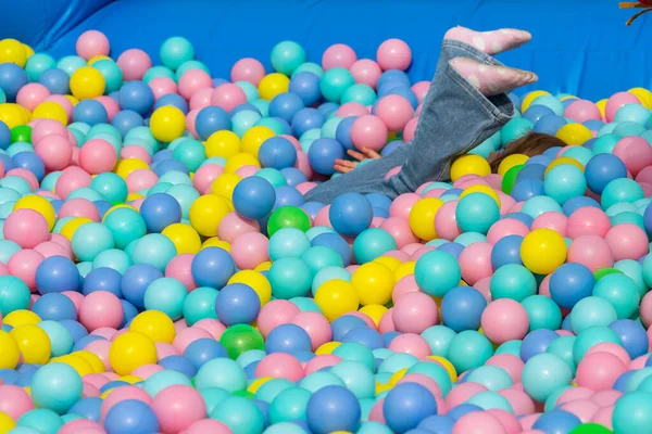 Açık hava basketbol potası, ağdan geçen bir top, açık mavi bir gökyüzüne ve arka plandaki kentsel binalara karşı.