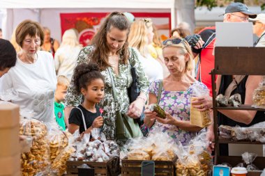 Vilnius, Litvanya - 7 Eylül 2025: İnsanlar Vilnius, Litvanya, Avrupa 'da bir sokak yiyecek ve zanaat pazarından şeker satın alıyorlar