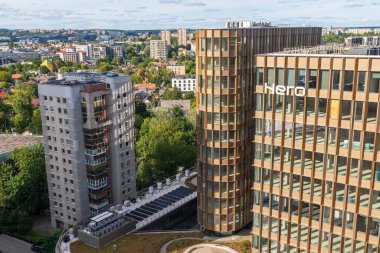 Vilnius, Litvanya - 20 Ağustos 2025: Günbatımında modern ticaret bölgesi yeni yüksek katlı cam ofis binaları ve şehir silueti, kurumsal büyümeleri simgeliyor