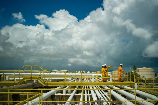 Multi-gender and ethnic Petroleum Workers on Refinery Area