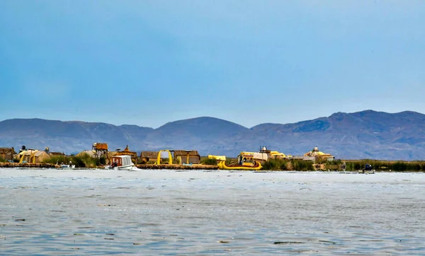 ウロス島 ティチカカ湖の眺めウロスルは 湖の岸に沿って豊富な葦を使用して 彼らの家 ボート 彼らが住んでいる島を作ります 船首に動物の頭を持つ彼らのカヌー型のボートが使用されています — ストック写真
