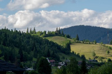 view from the top of a hill with a village in the foreground.