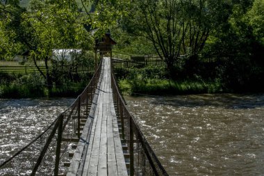 Ormanda, nehrin üzerinde tahta köprü.