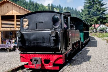 Güneşli yaz gününde, dağların arka planında eski ahşap buhar treni..
