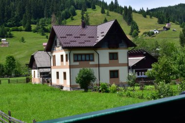 Yazın dağlarda bir dağ evi manzarası.