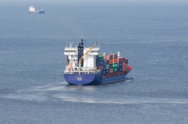 SUÇLU, BATI POMERANYA / POLAND - 2020: Konteyner gemisi liman kanalından bir deniz yolculuğuna çıkıyor
