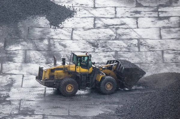 WHEEL LOADER - Machine at work on the yard of a coal storage site in rainy weather