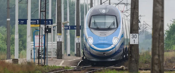 ÜSTRONİE MORSKIE, BATI POMERANYA / POLAND - 2020: Ekspres tren tren tren yolu üzerindeki küçük bir istasyondan geçer