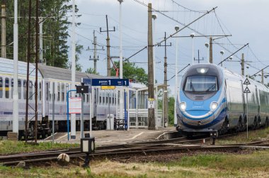 ÜSTRONİE MORSKIE, BATI POMERANYA / POLAND - 2020: Ekspres tren tren tren yolu üzerindeki küçük bir istasyondan geçer