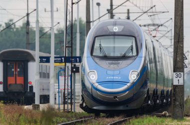 ÜSTRONİE MORSKIE, BATI POMERANYA / POLAND - 2020: Ekspres tren tren tren yolu üzerindeki küçük bir istasyondan geçer