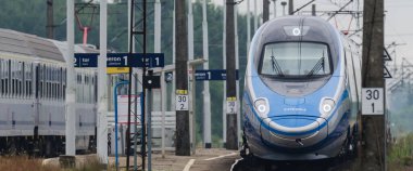 ÜSTRONİE MORSKIE, BATI POMERANYA / POLAND - 2020: Ekspres tren tren tren yolu üzerindeki küçük bir istasyondan geçer