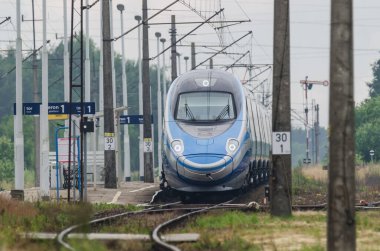 ÜSTRONİE MORSKIE, BATI POMERANYA / POLAND - 2020: Ekspres tren tren tren yolu üzerindeki küçük bir istasyondan geçer