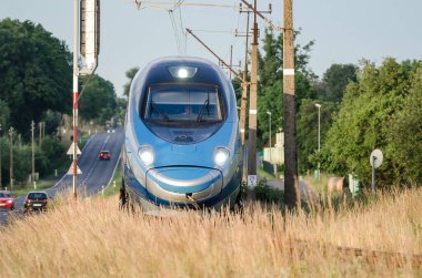 ÜSTRONİE MORSKIE, BATI POMERANYA / POLAND - 2020: Ekspres tren tren tren yolu üzerindeki küçük bir istasyondan geçer