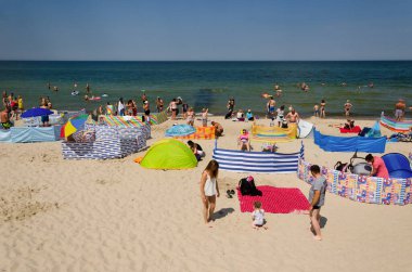 SARBINOWO, BATI POMERANYA / POLAND - 2020: Tatil turistleri güneşli deniz sahillerinde dinleniyor