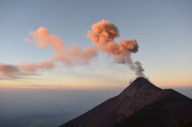 Volkan del Fuego, Volkan Acatenango yanardağının yanında. Gün doğumunda renkli dumanlar püsküren volkan.