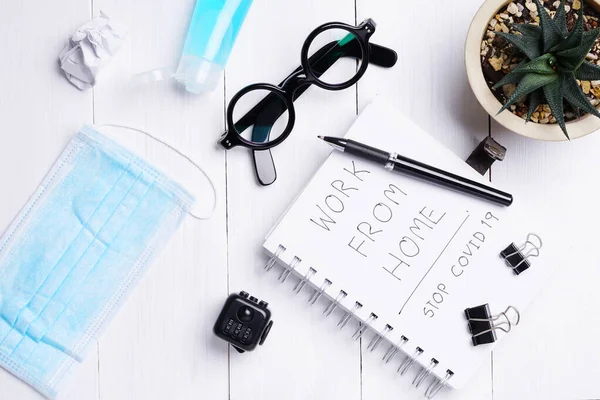 Düz, üst kattaki ofis beyaz masa ahşap masa. Çalışma alanı boş gözlükler, günlük, maske ve arka planda akıllı telefon. Evden çalışmak.