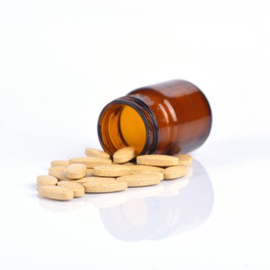 İki ölçü C vitamini şişesi ve yansımalı hap.