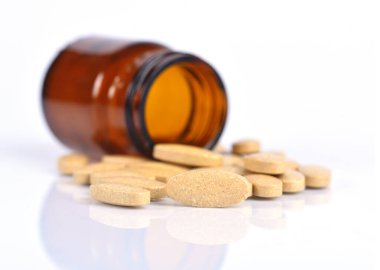 İki ölçü C vitamini şişesi ve yansımalı hap.