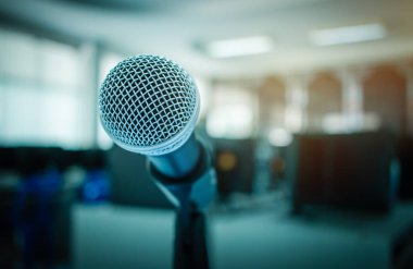 Seminer odasında konuşmanın bulanık olduğu soyut bir mikrofon ya da konferans salonu ışığı, bilgisayar arkaplanı...