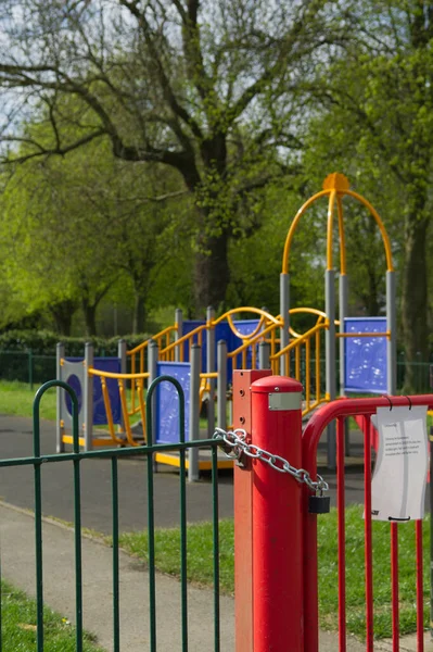 Red fence with a gate locked with a padlock. Closed and locked Play area due to Covid 19 Hinckey, Leistershire UK