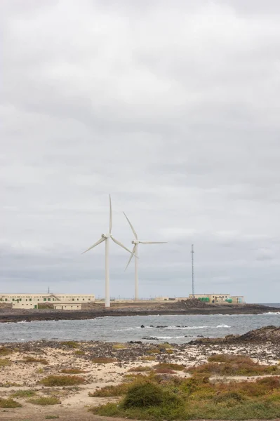 Rüzgâr türbinleri Corralejo 'nun kuzeyindeki su işleme tesisinde bulutlu bir günde. Metni kopyalamak için kalan boşluk.