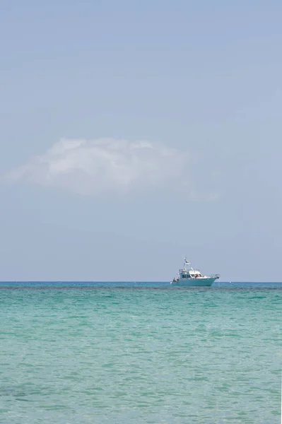Beyaz dalgalı deniz burnu, bir dalış botu ve Los Lobos adasından bakan mavi gökyüzü. Metni kopyalamak için kalan boşluk.