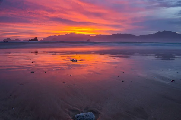 Pôr Sol Praia Com Céu Vermelho Alaranjado Refletido Areias Molhadas — Fotografia de Stock