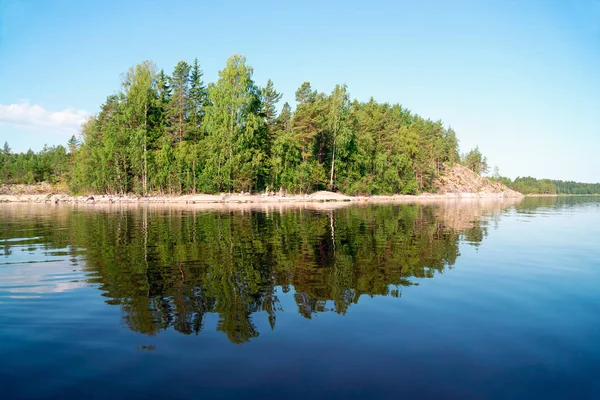 Каменный остров с отражением в воде на озере. Ладога-Скеррис . — стоковое фото