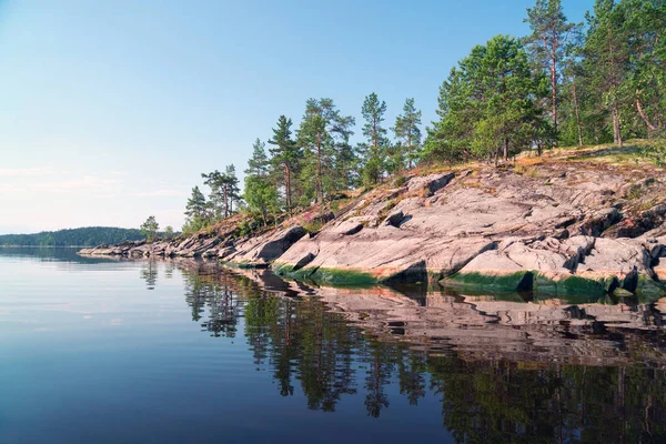 Stone sziget tükrözi a víz a tavon. Ladoga Skerries, Karelia. — Stock Fotó