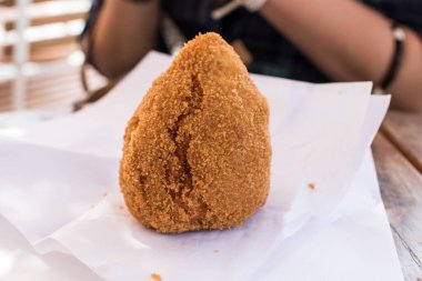 Sicilya usulü paçavra bir gastronomik yemek, et soslu kızarmış pirinç köftesi, İtalyan sokak yemeği.